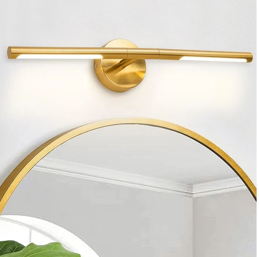 Lámpara de baño dorada sobre espejo